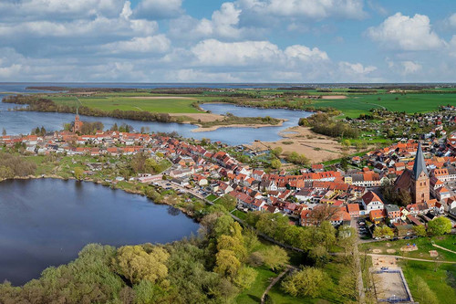 Luftaufnahme einer Kleinstadt am Rande einer Seenplatte