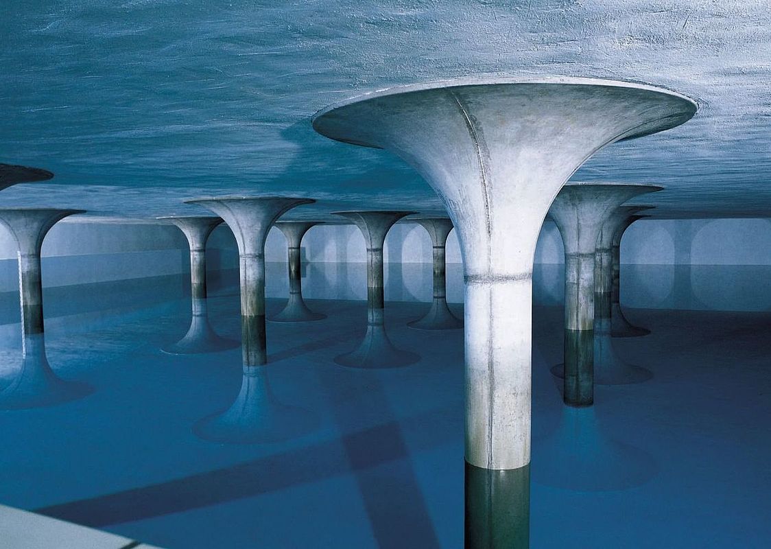 Ein fensterloser Raum aus Beton, die Decke mit vielen pilzförmigen Pfeilern gestützt, die im Wasser stehen